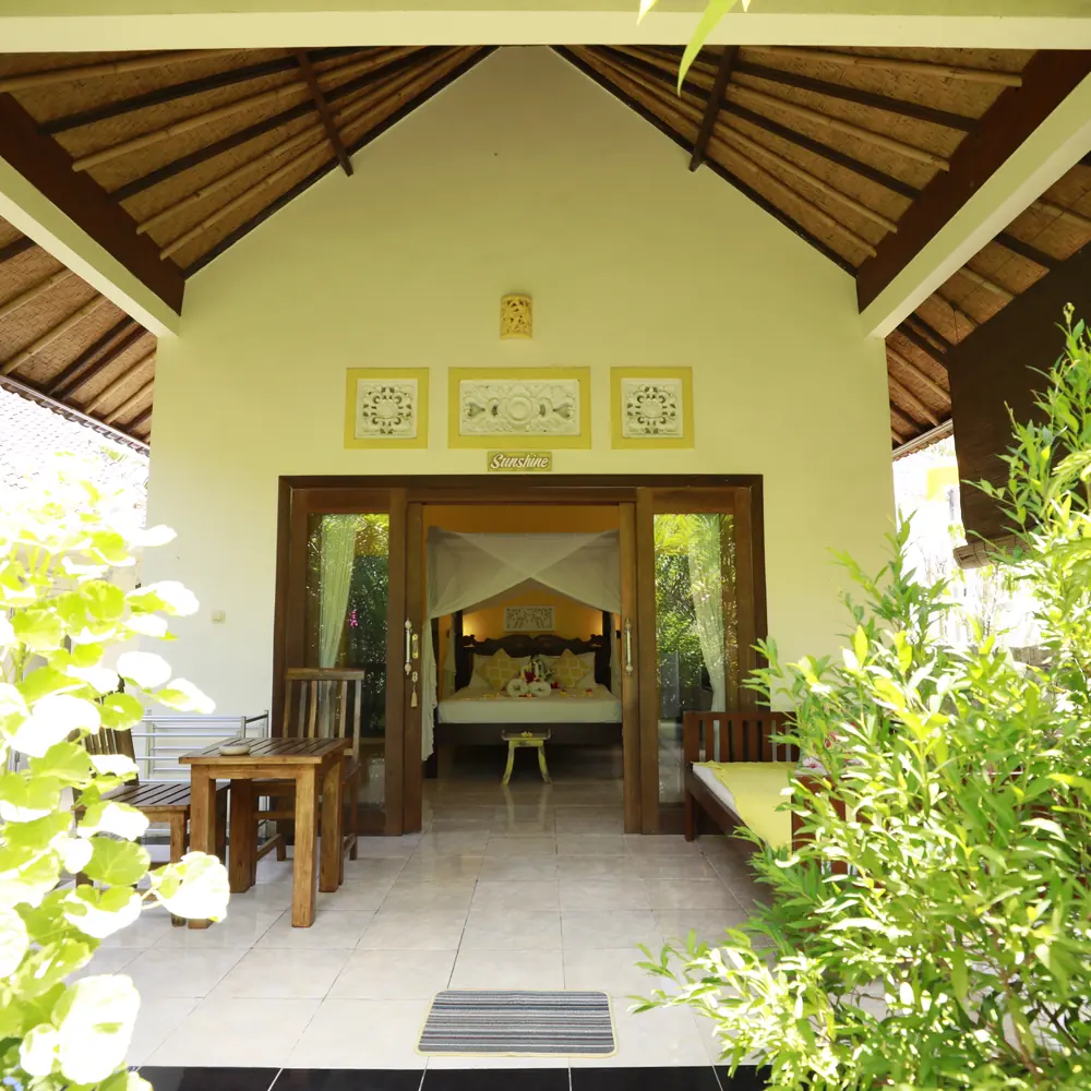 A bungalow terrace with a daybed and plants