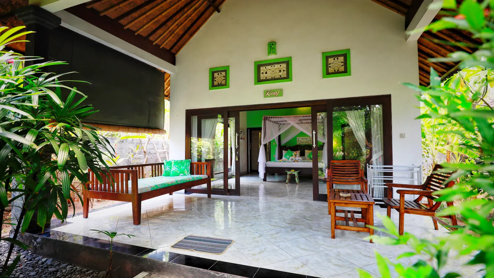 Terrace of a Kirana bungalow with a daybed, chairs and tropical plants