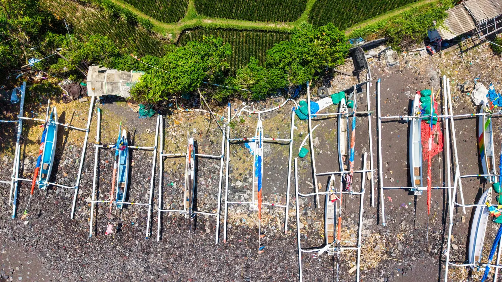 Aerial view of fishing boats on the dark sand shore near Amed