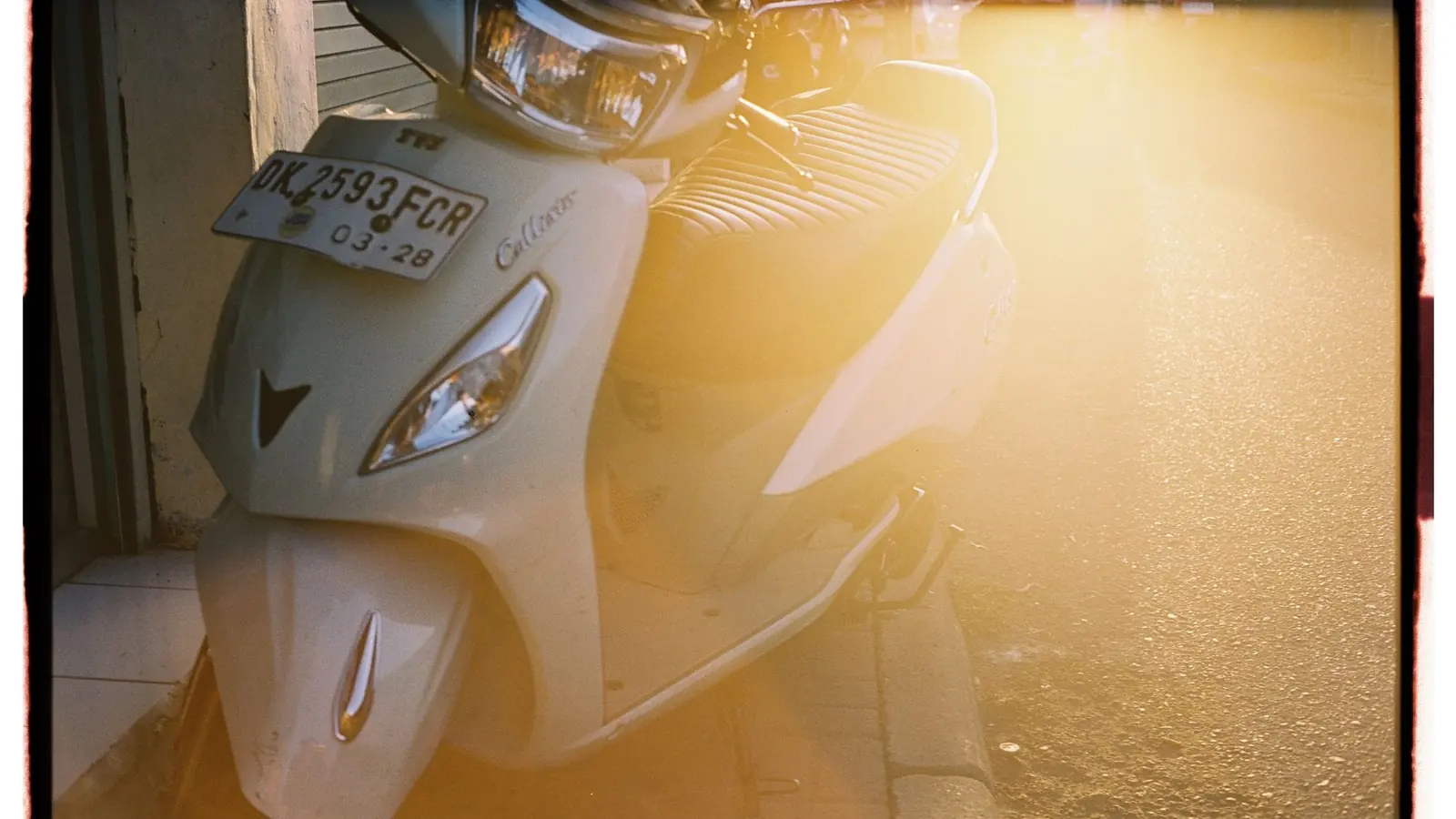 A scooter parked in warm afternoon light